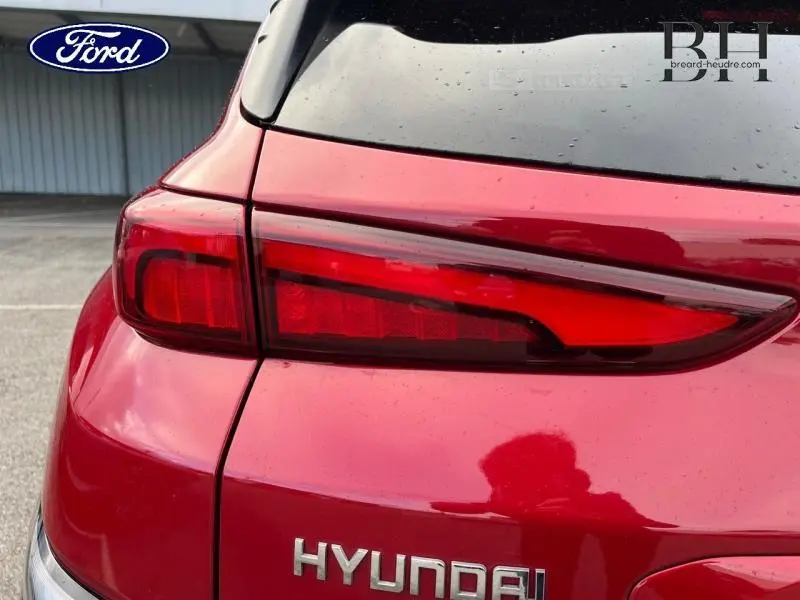 Gros plan sur le feu arrière gauche rouge d’un Hyundai Kona Pulse Red Métal 2022, avec logo Hyundai visible.