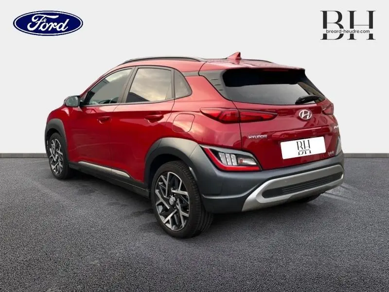 Vue 3/4 arrière droite d'un Hyundai Kona Pulse Red Métal avec jantes alu et protections noires contrastantes.
