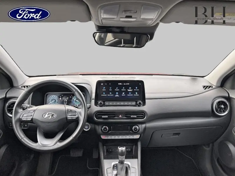 Vue intérieure frontale du tableau de bord noir du Hyundai Kona 2022 avec écran tactile central et volant multifonction.