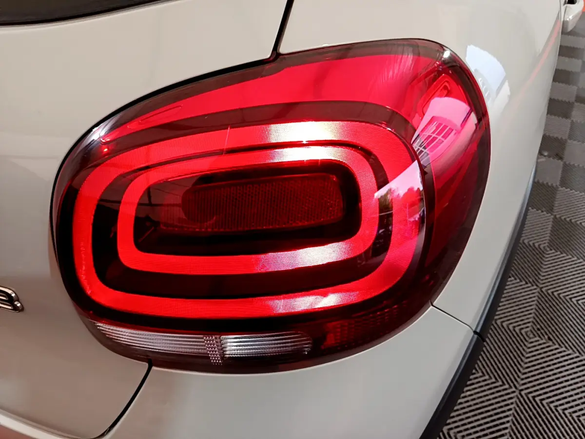 Gros plan sur le feu arrière droit rouge d’une Citroën C3 beige 2022, mettant en valeur son design lumineux distinctif.