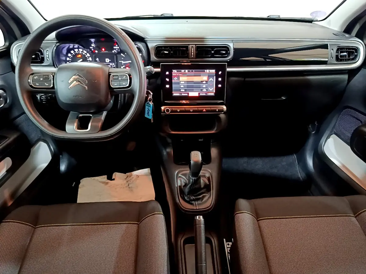 Vue intérieure avant de la Citroën C3 2022 avec tableau de bord noir, volant multifonctions et écran tactile central.