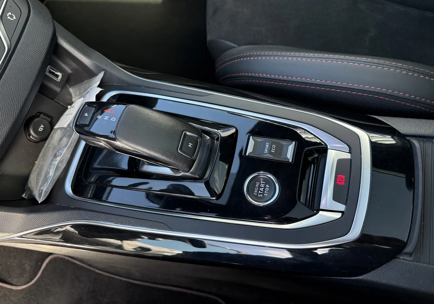 Gros plan sur la console centrale de la Peugeot 308 SW blanche nacrée, avec levier de vitesse automatique et boutons Start/Stop, Sport et Eco.