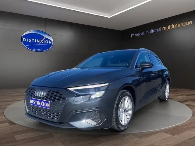 Audi A3 30 TDI gris foncé vue 3/4 avant droit, avec calandre hexagonale et phares LED allumés.