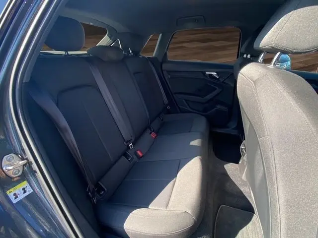 Vue intérieure arrière côté gauche de l’Audi A3 30 TDI 116 Business Line 2021 en gris foncé, banquette trois places en tissu.