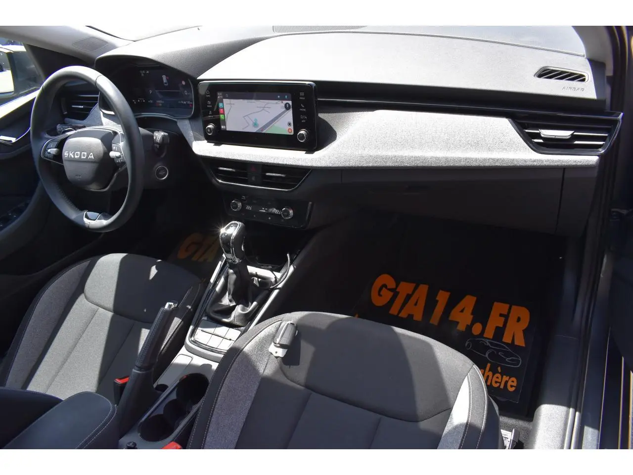 Vue intérieure côté conducteur de la Skoda Scala 2025 avec tableau de bord noir et écran tactile central.