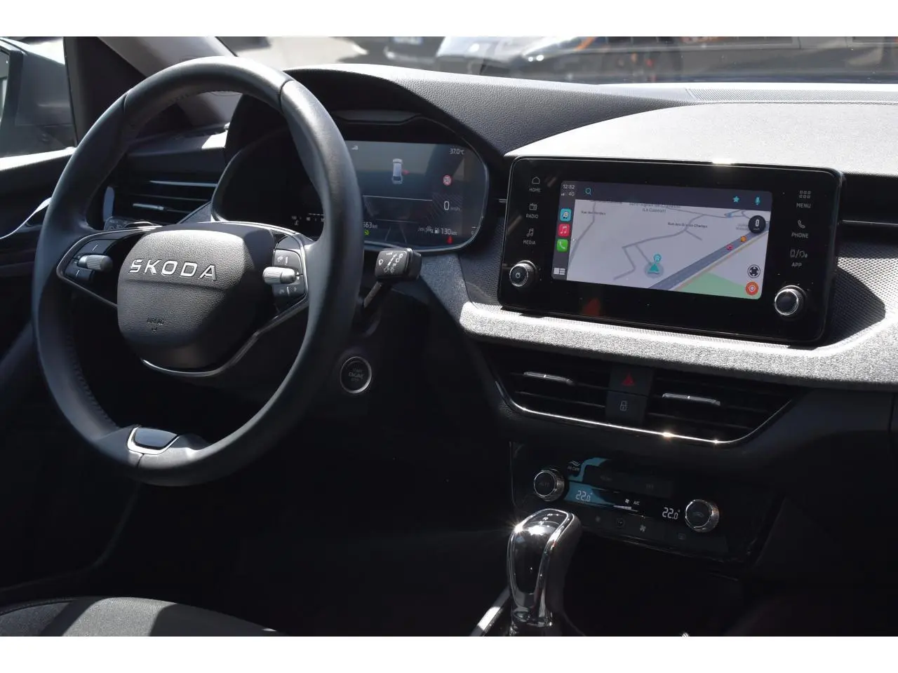 Vue intérieure côté conducteur du Skoda Scala 2025, tableau de bord avec écran tactile et volant multifonctions noir.