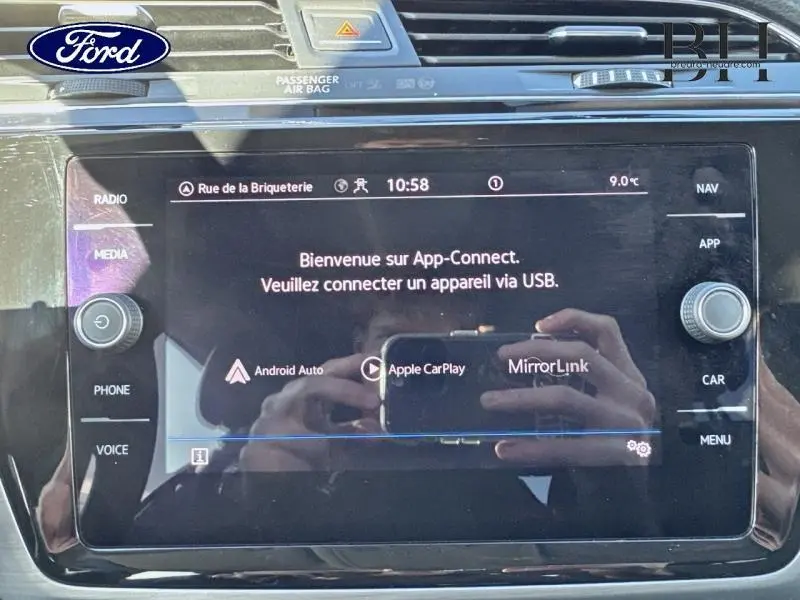 Écran tactile central du Volkswagen Touran 2023 affichant l'interface App-Connect avec commandes autour.