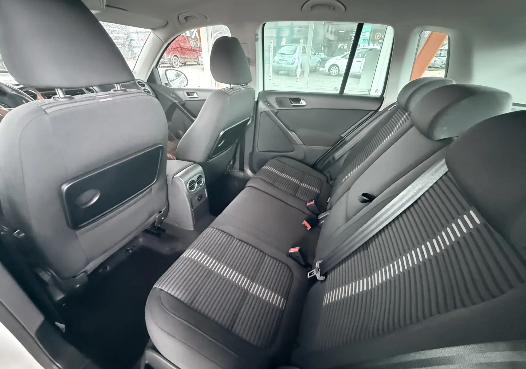 Vue intérieure arrière du Volkswagen Tiguan 2.0 TDI 140 de 2010, sièges en tissu noir avec motifs clairs.