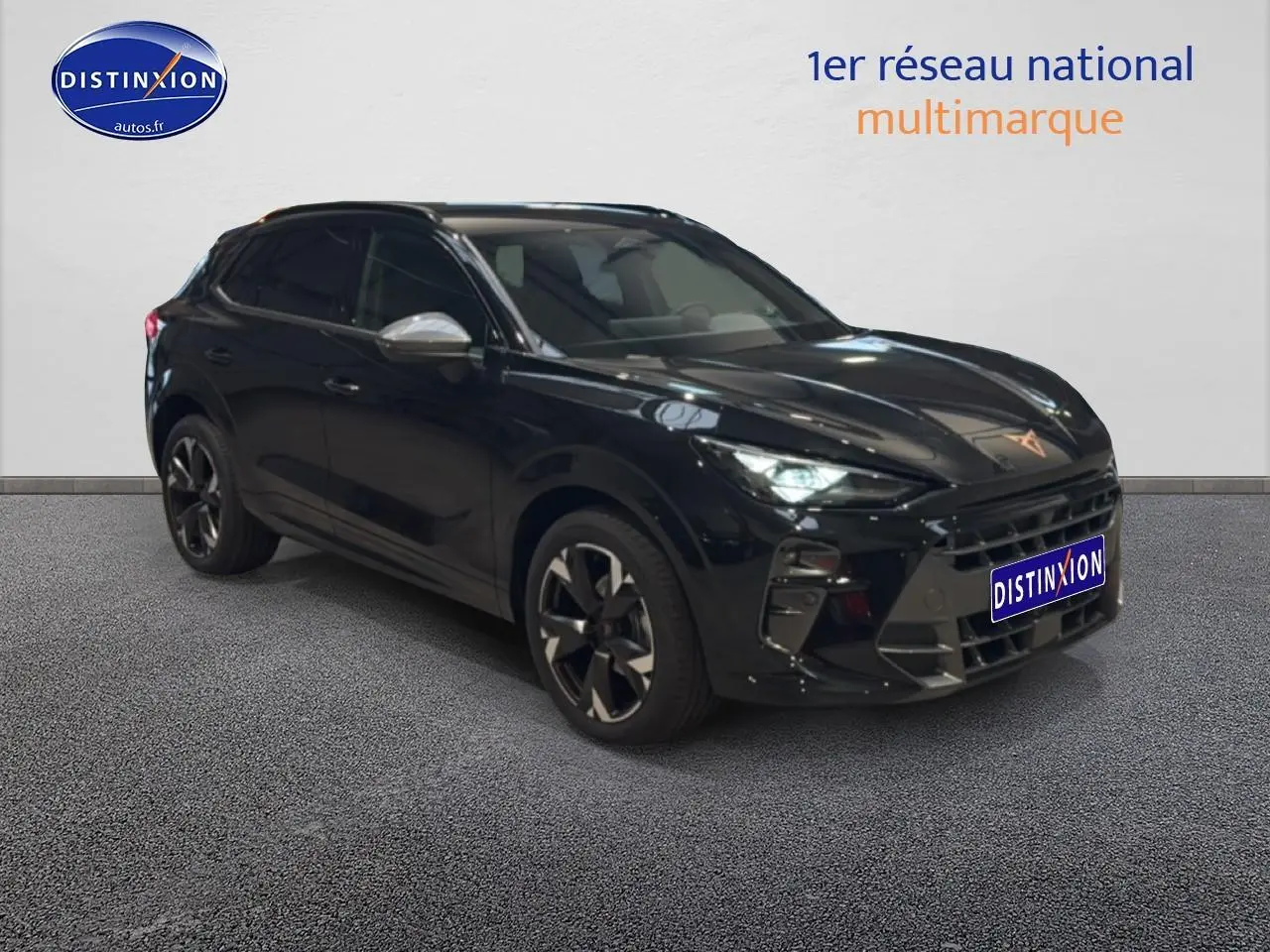 Vue 3/4 avant d'une CUPRA Terramar noire avec jantes 19 pouces et vitres surteintées dans un showroom.