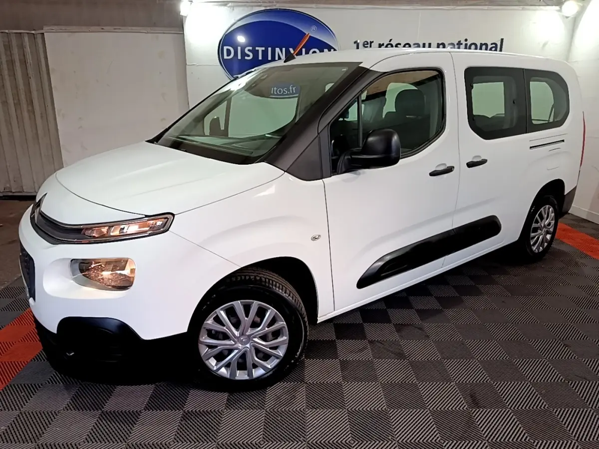 Vue 3/4 avant droit du Citroën Berlingo blanc XL avec protections latérales noires et jantes alliage.