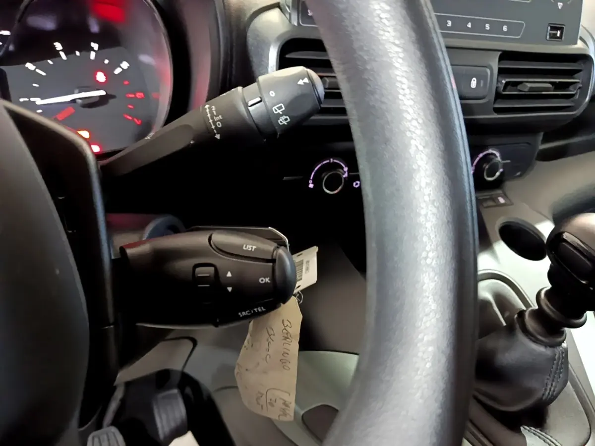 Vue rapprochée du volant et du levier de vitesses manuel dans l’habitacle noir du Citroën Berlingo blanc 2019.