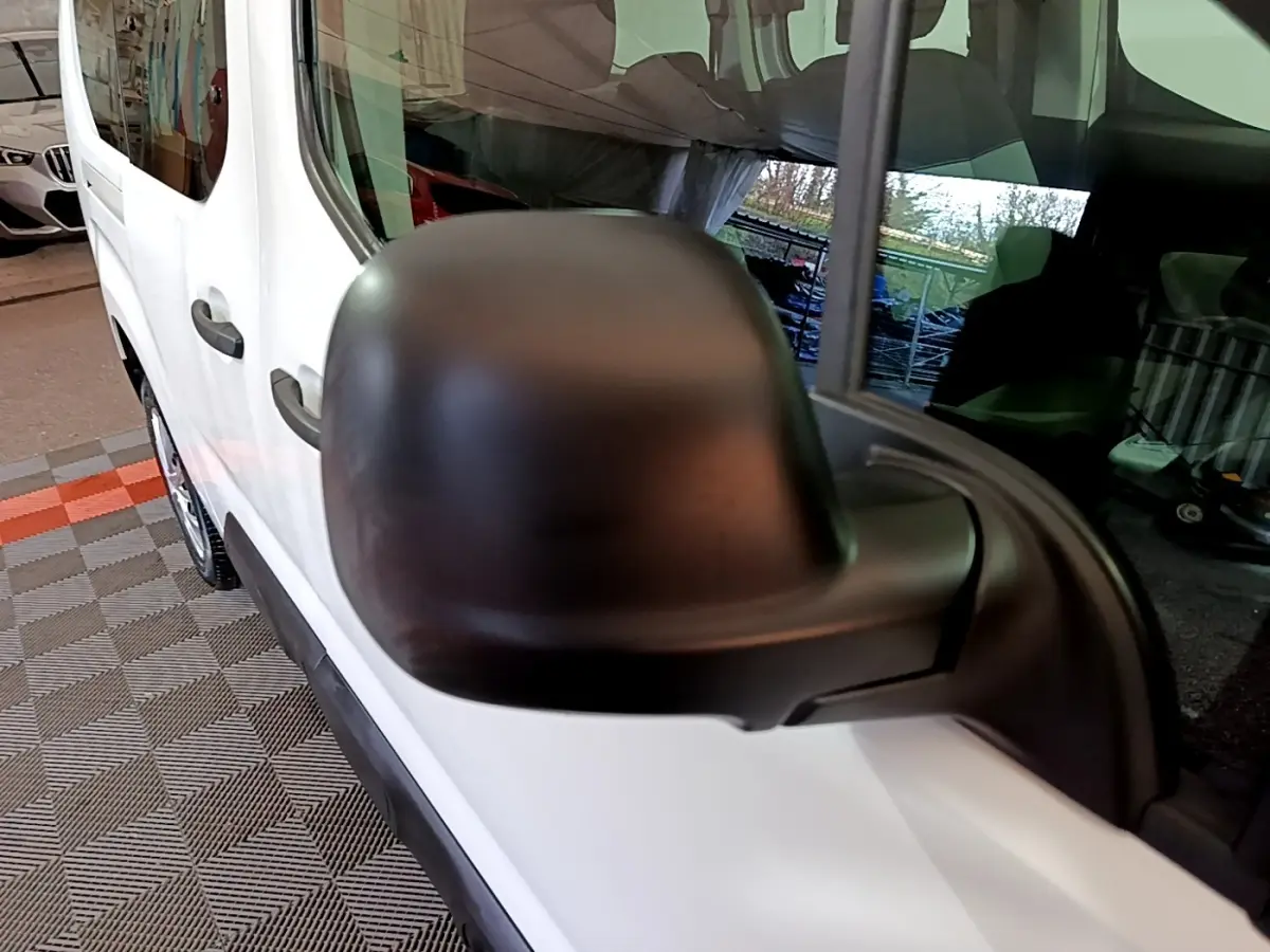 Gros plan sur le rétroviseur noir côté conducteur du Citroën Berlingo XL blanc, vue latérale gauche.