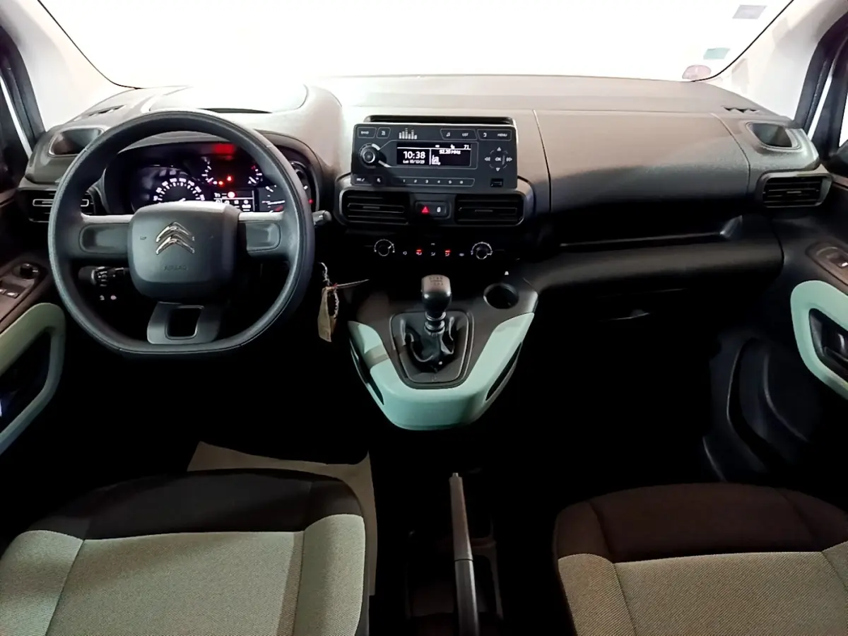 Vue intérieure avant du Citroën Berlingo XL 2019, tableau de bord noir avec volant et levier de vitesses manuels.