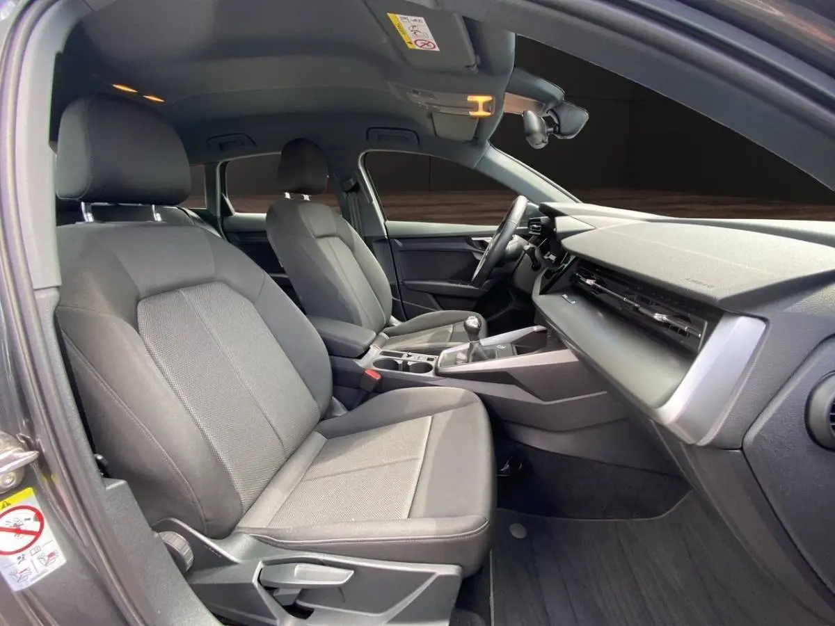 Vue intérieure côté conducteur de l'Audi A3 30 TFSI 110 S Line 2021 avec sièges gris et tableau de bord moderne.