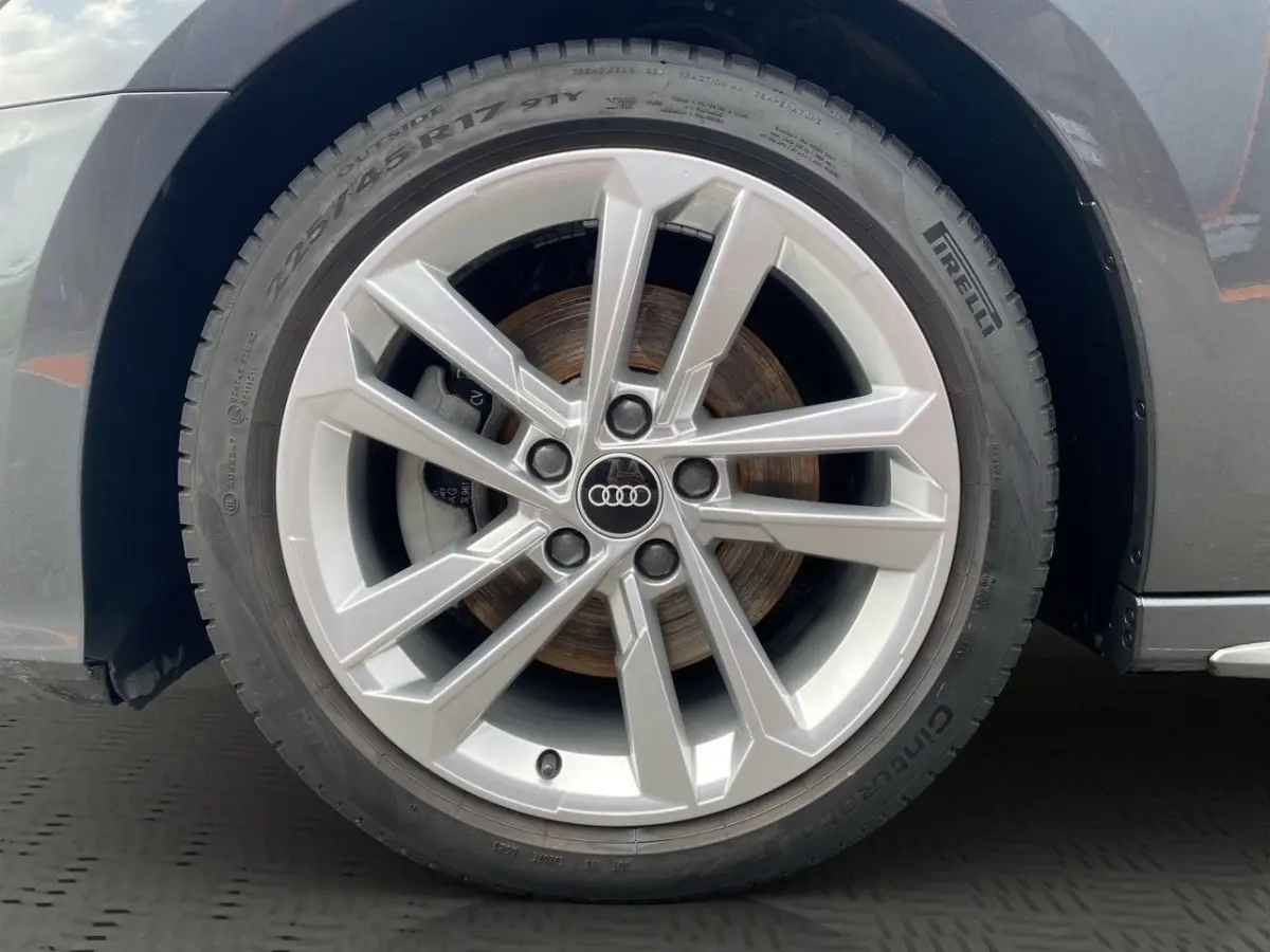 Gros plan sur la roue avant droite d'une Audi A3 gris foncé, jante alliage à design moderne en étoile.