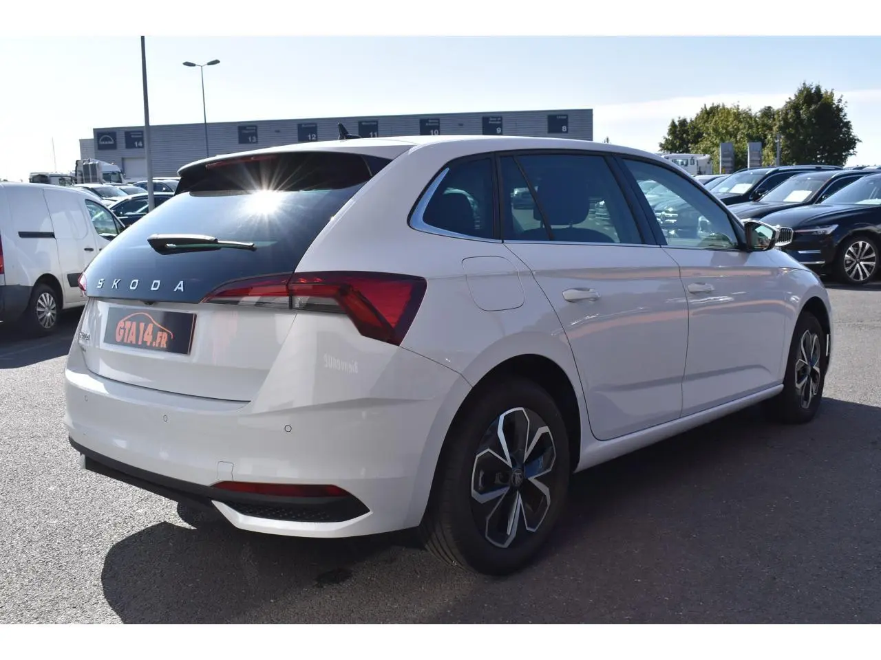 Vue 3/4 arrière droite d'une Skoda Scala blanche Glacier avec vitres surteintées et jantes originales.