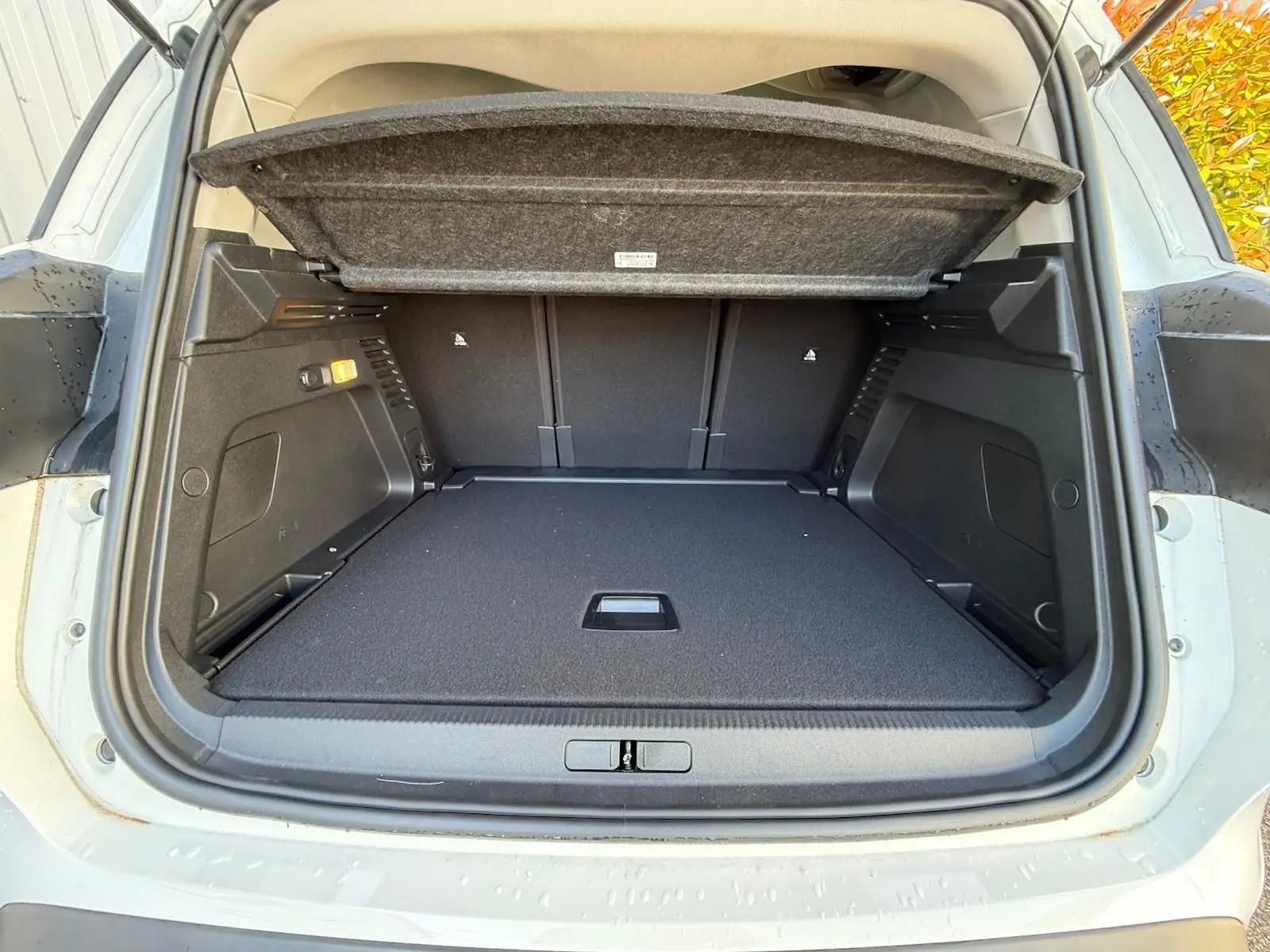 Coffre ouvert vu de l'arrière du Citroën C5 Aircross blanc banquise, montrant un espace de chargement propre et spacieux.