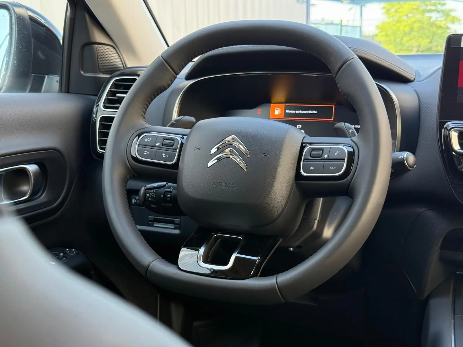 Volant multifonction noir de Citroën C5 Aircross 2024 hybride, vue rapprochée de l'intérieur côté conducteur.
