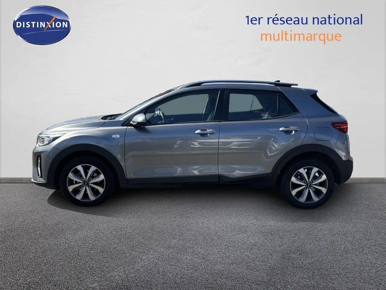 Profil côté gauche d'un Kia Stonic gris météore 2024, compact 5 portes avec jantes bi-ton et toit noir.