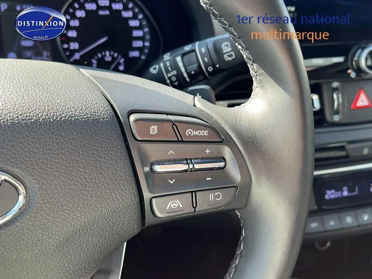 Gros plan sur le volant cuir multifonction de la Hyundai i30 gris argent avec commandes de régulateur et mode.