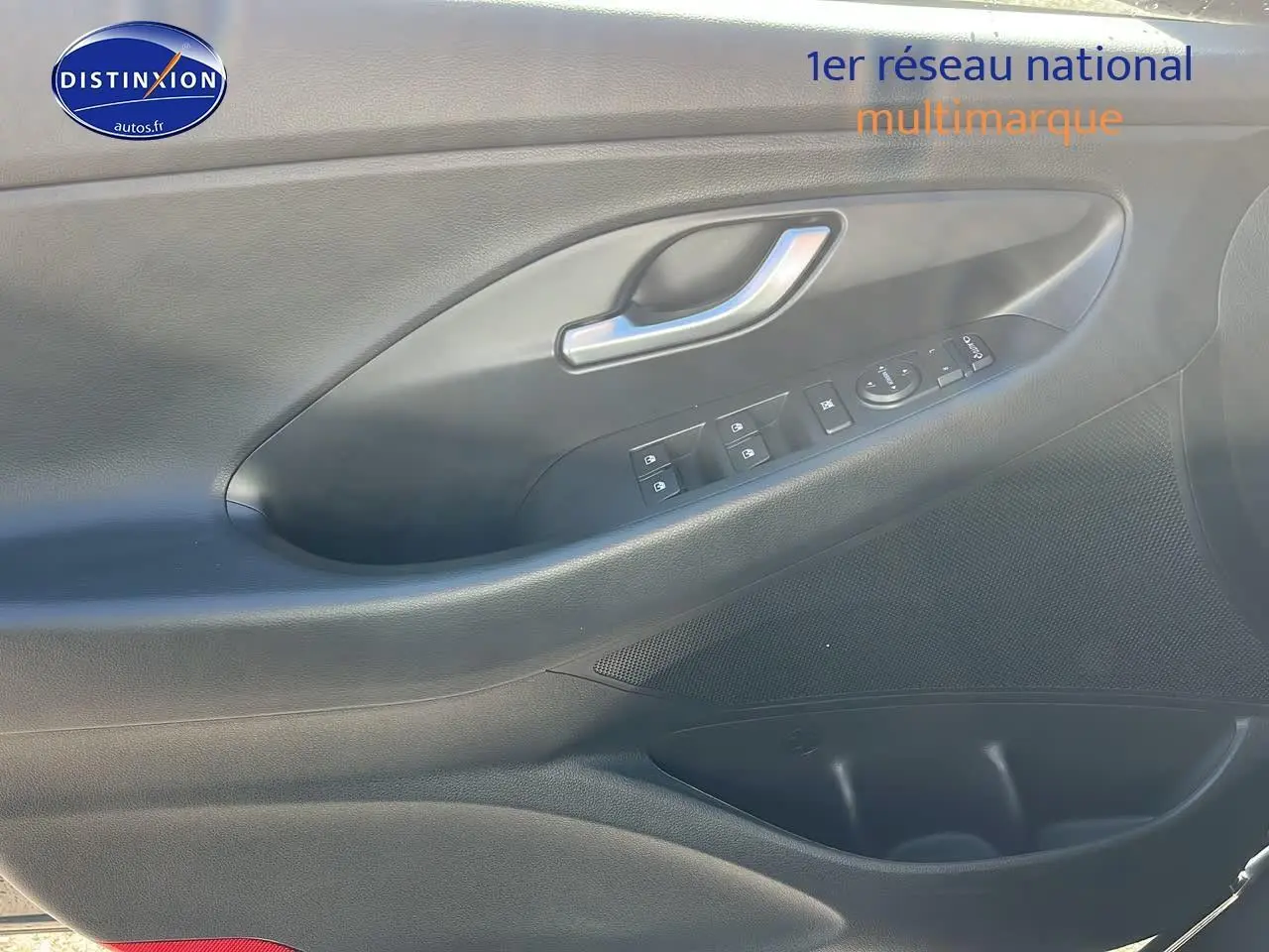 Gros plan sur la porte côté gauche intérieure grise avec commandes électriques et poignée argentée d'une Hyundai i30 2024