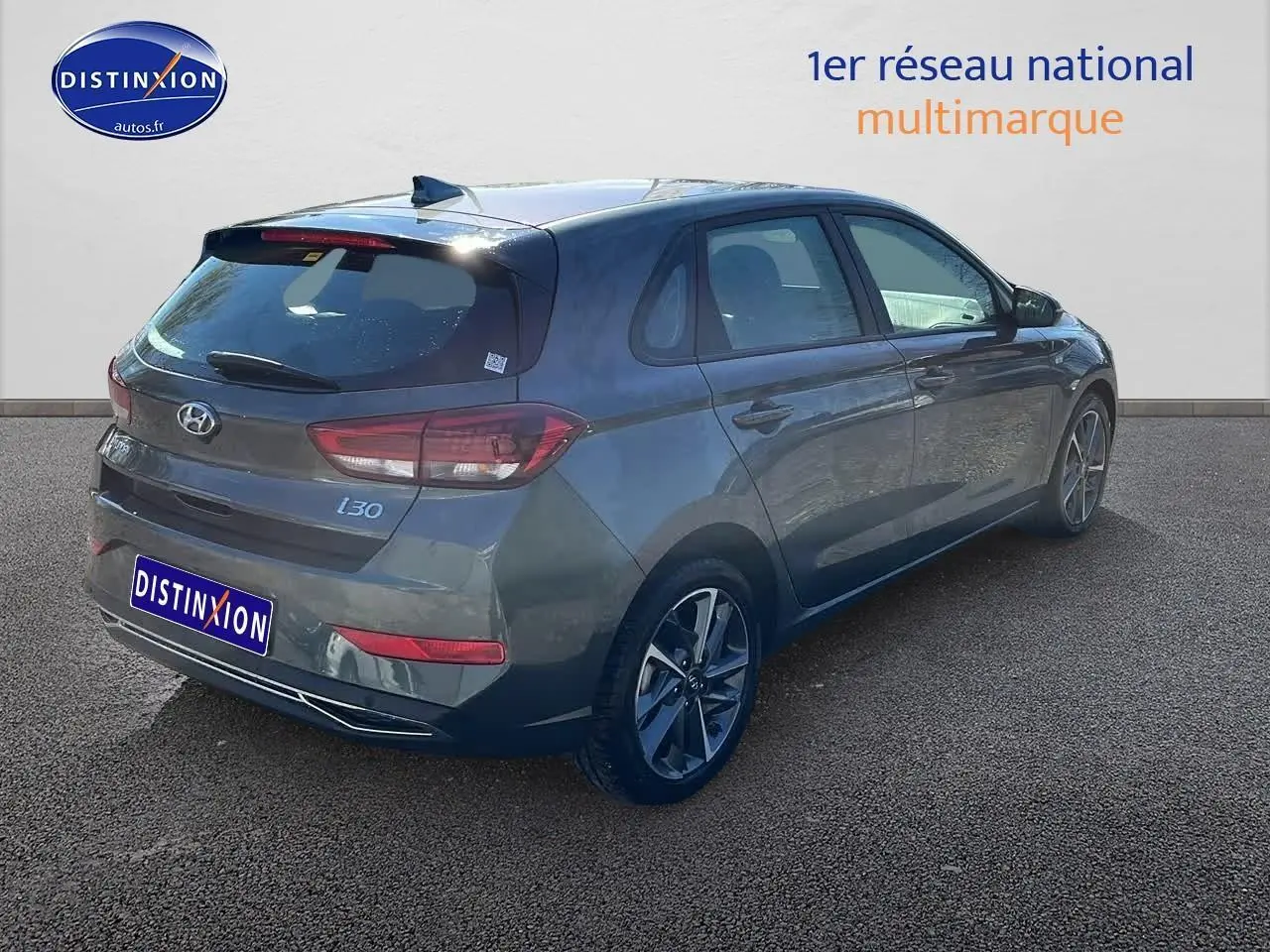 Hyundai i30 gris argent vue 3/4 arrière droit, avec jantes alliage et feux arrière LED distinctifs.
