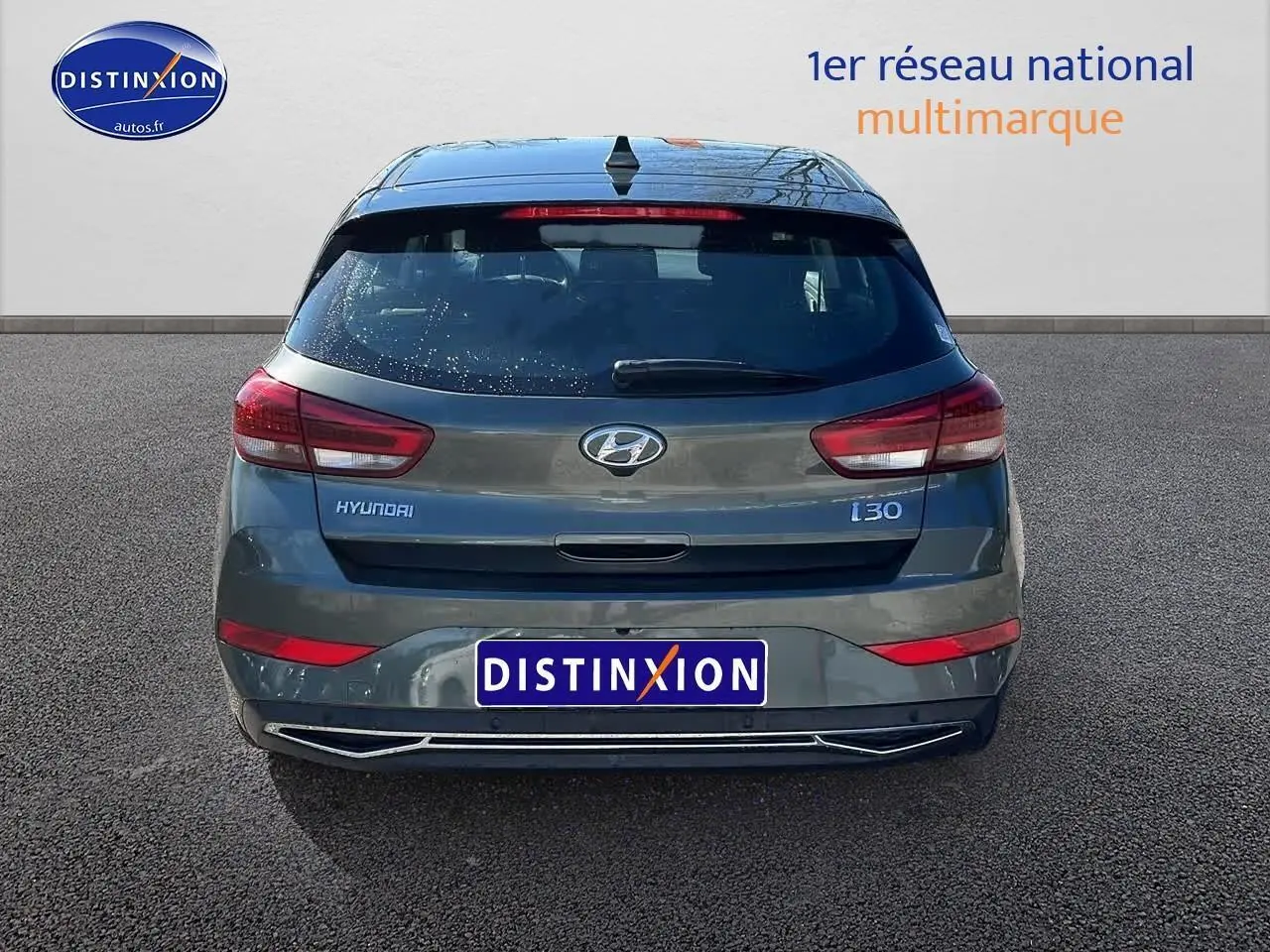 Vue arrière d'une Hyundai i30 gris argent 2024 avec feux LED et logo Hyundai bien visibles.