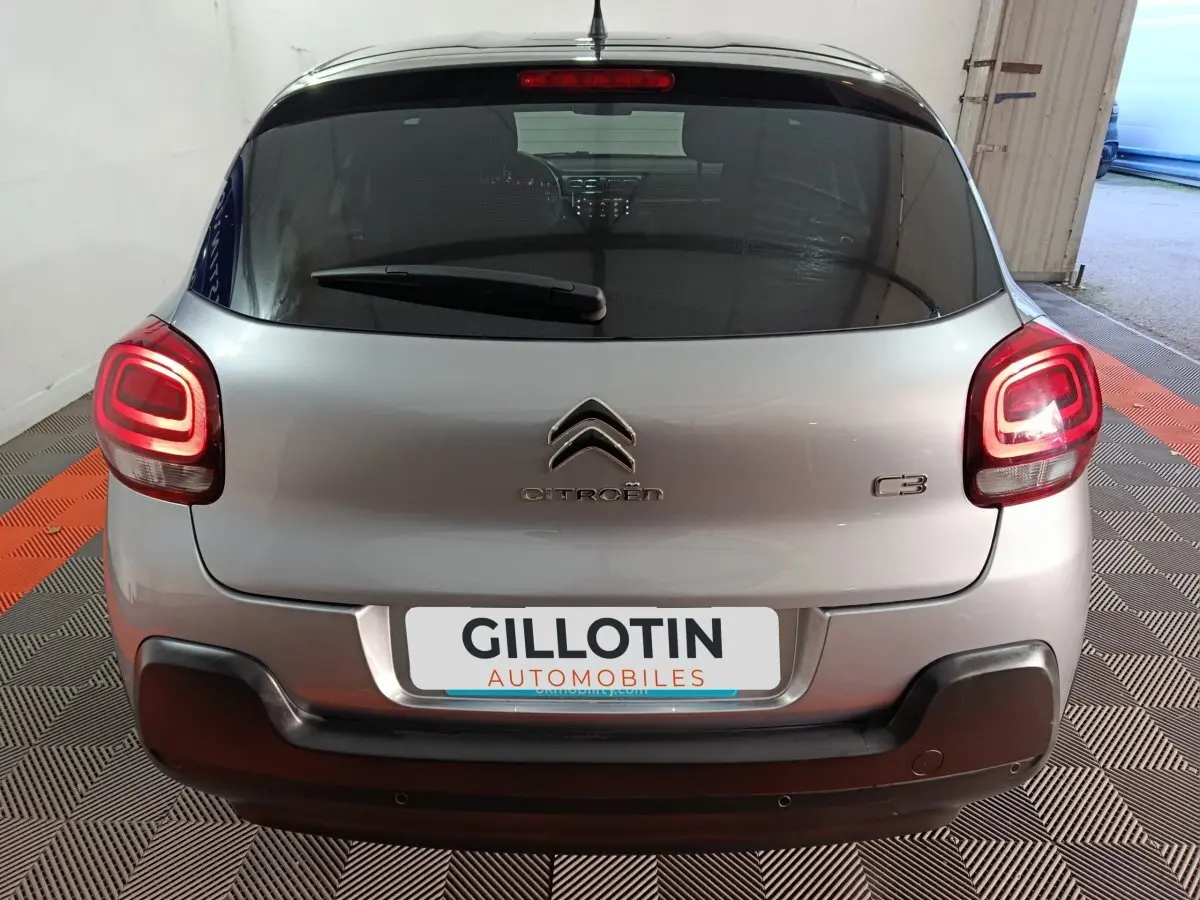 Vue arrière d'une Citroën C3 gris foncé avec feux LED allumés et pare-chocs noir contrastant.
