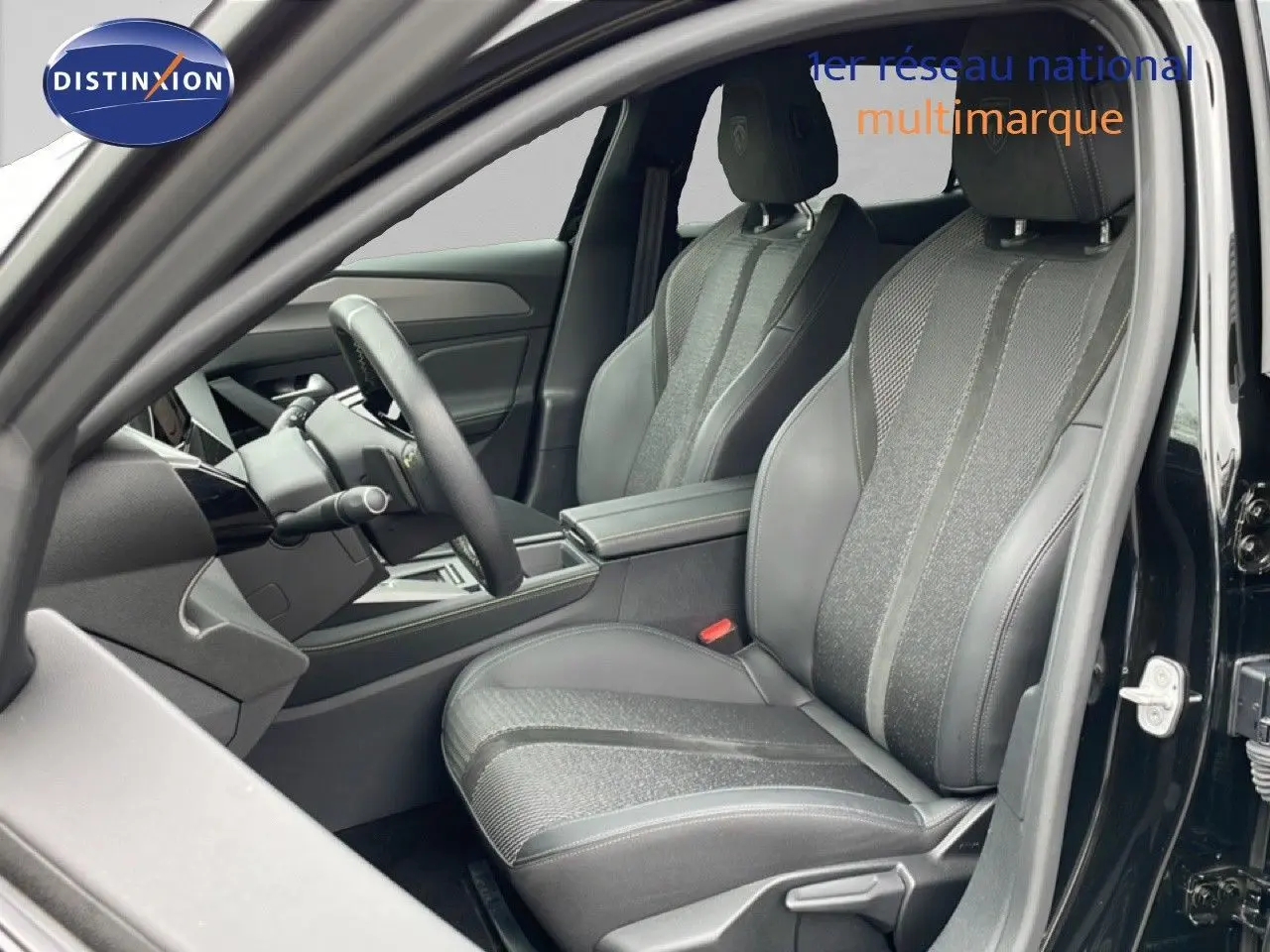 Vue intérieure côté conducteur du Peugeot 408 Hybrid 145ch GT noir métal, sièges en cuir et tissu gris avec console centrale visible.