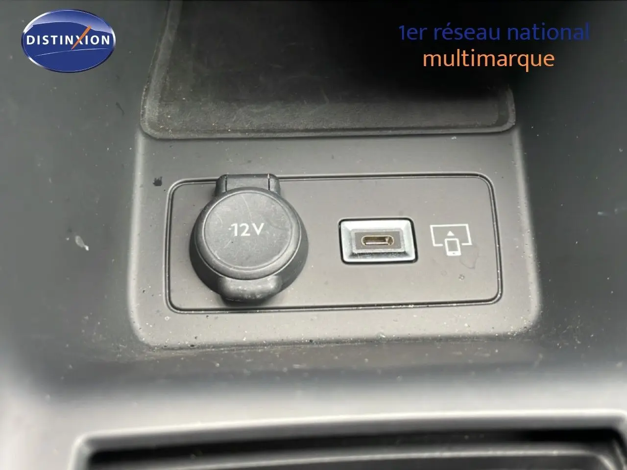 Gros plan sur la prise 12V et port USB-C dans l’intérieur noir du Peugeot 408 Hybrid 145ch GT 2024.