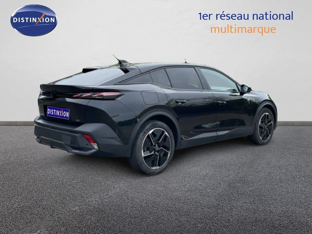 Peugeot 408 Hybrid noir métal vue 3/4 arrière droit, soulignant ses lignes dynamiques et jantes noires distinctives.