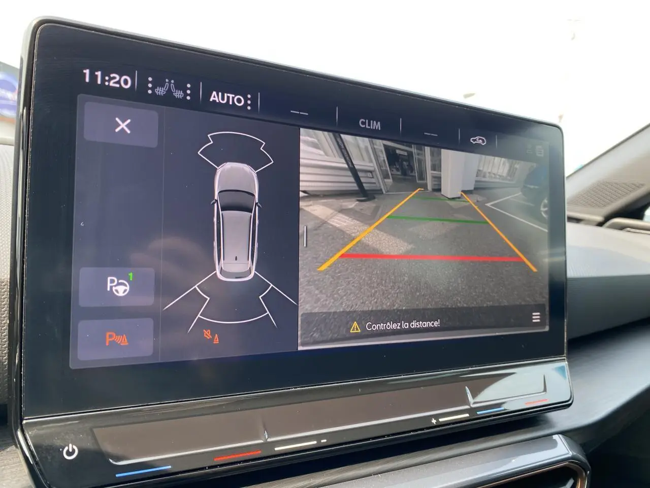 Écran tactile intérieur affichant la caméra de recul et l'aide au stationnement du CUPRA LEON ST noir Midnight 2024.