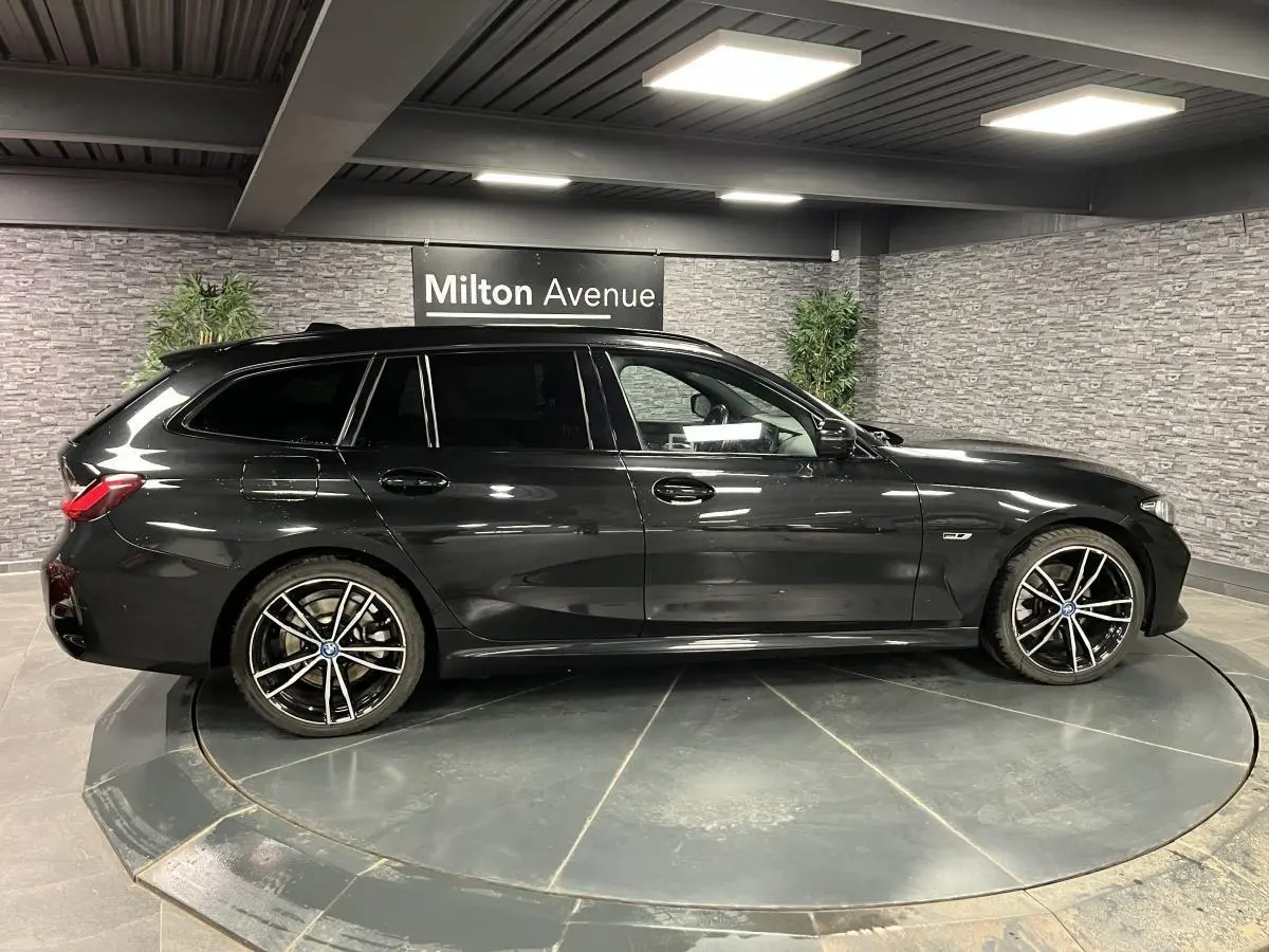 BMW Série 3 320e Touring noir vue de profil côté gauche avec jantes M Sport 19 pouces bicolores