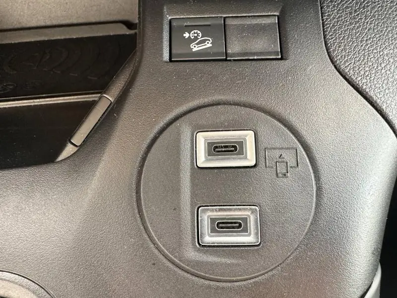 Gros plan sur deux ports USB-C et bouton d'assistance à la descente dans l'habitacle gris du Citroën Berlingo XL 2024.
