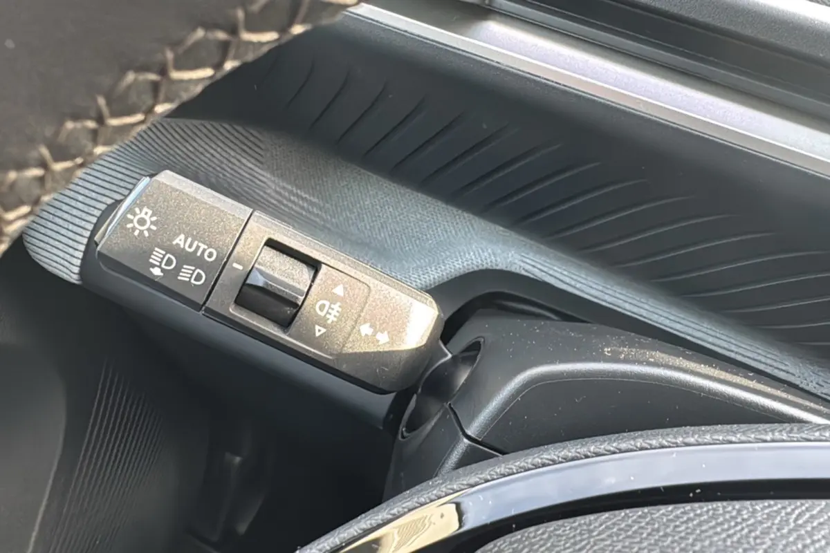 Gros plan sur la commande des feux au volant d'une Citroën C3 Aircross noir Perla Nera, finition 2025.