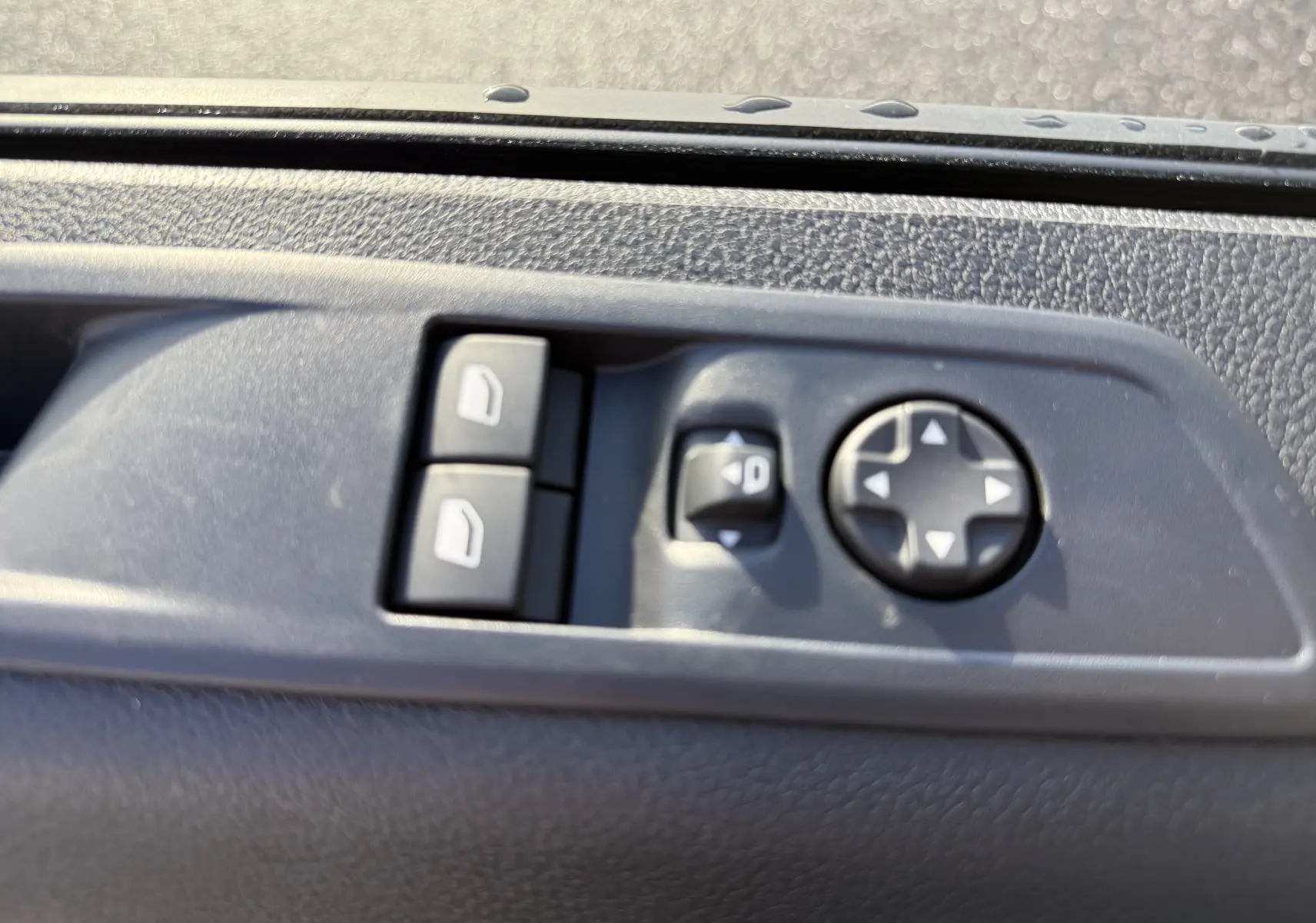 Boutons de commande des vitres et réglage des rétroviseurs sur la portière côté gauche du Citroën Jumpy Cabine Approfondie noir.