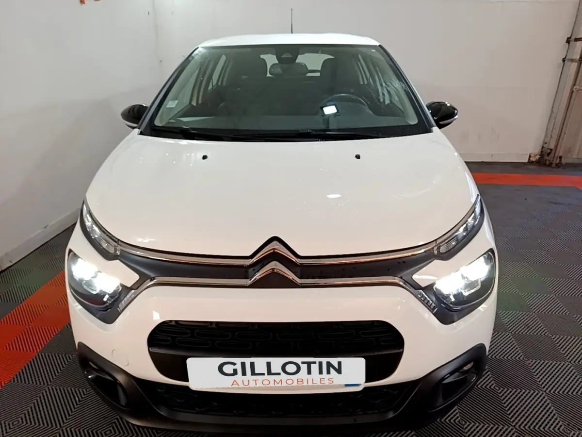 Vue avant d'une Citroën C3 blanche 2020 avec phares allumés et calandre noire distinctive.