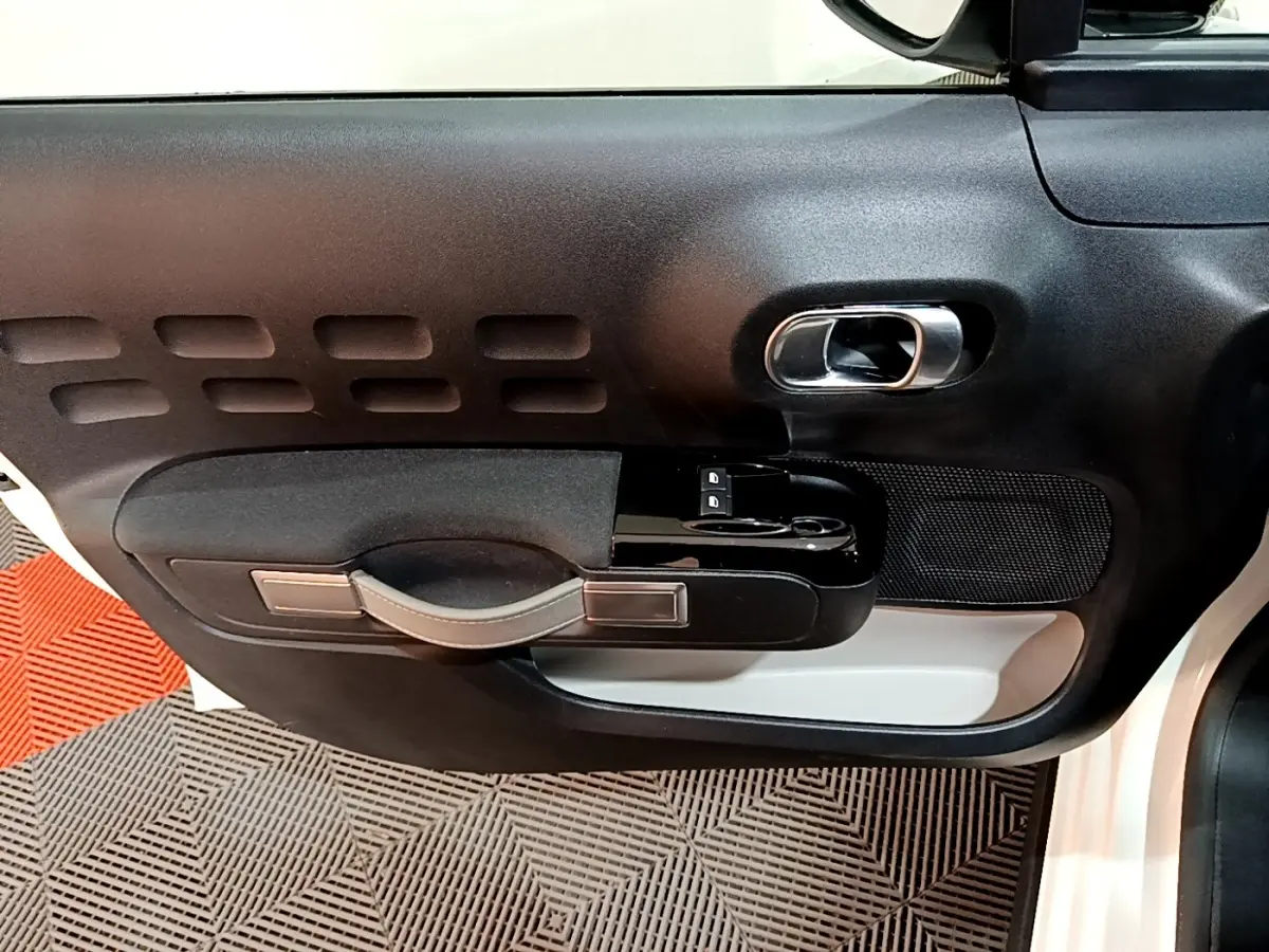 Vue rapprochée de la porte avant gauche noire et blanche de la Citroën C3 PureTech 82 S&S BVM Feel Business 2020.