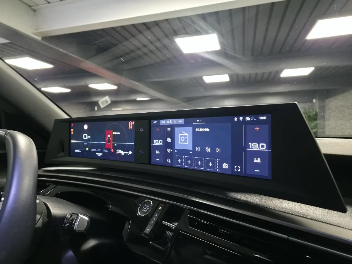Vue intérieure du tableau de bord du Peugeot 3008 bleu 2025, avec double écran HD panoramique et commandes numériques.