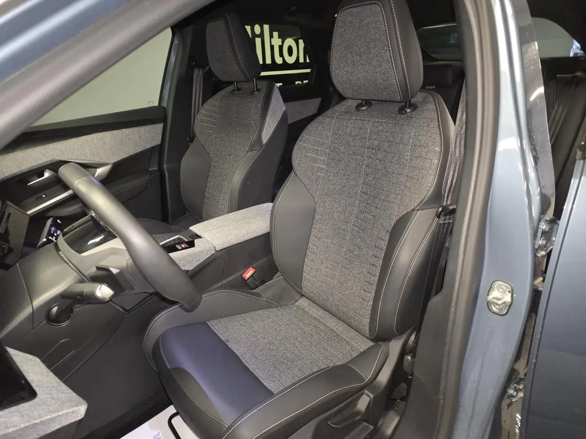 Vue intérieure côté conducteur du Peugeot 3008 2025 bleu, sièges tissu gris et cuir noir avec surpiqûres quartz.