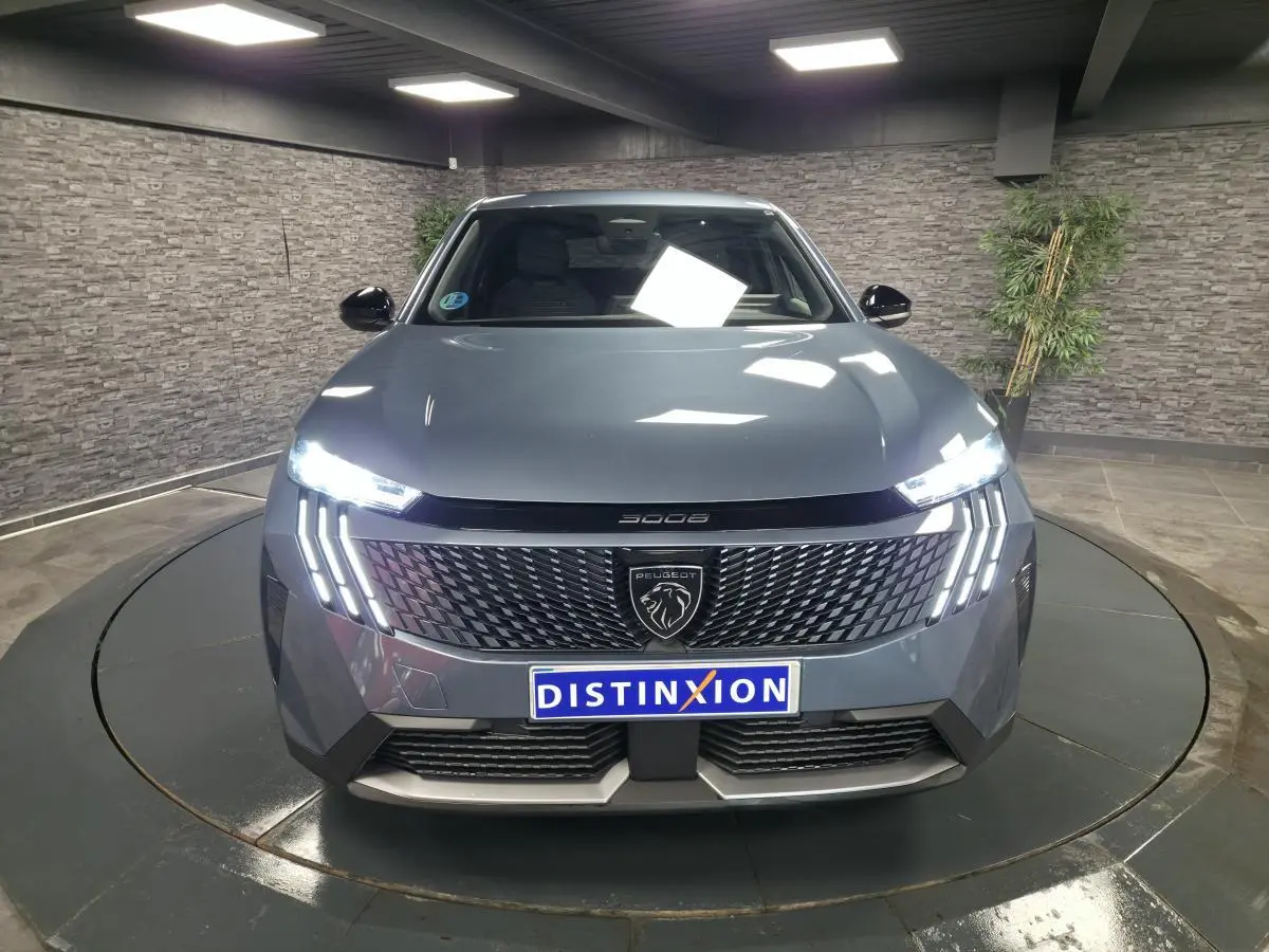 Vue avant d’un Peugeot 3008 bleu avec feux LED 3 griffes allumés et calandre noire brillante.