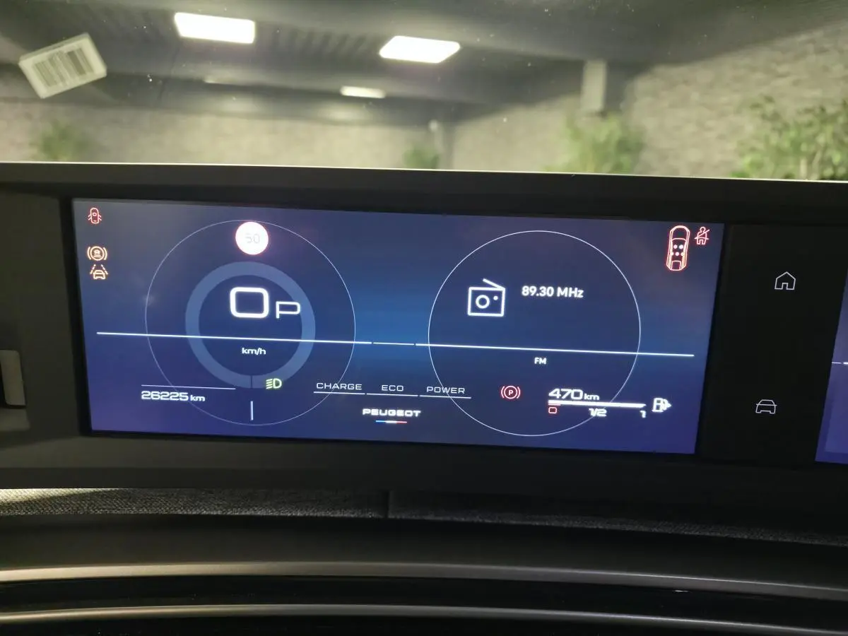 Affichage numérique du tableau de bord du Peugeot 3008 Hybrid 2025, montrant vitesse, radio et autonomie.