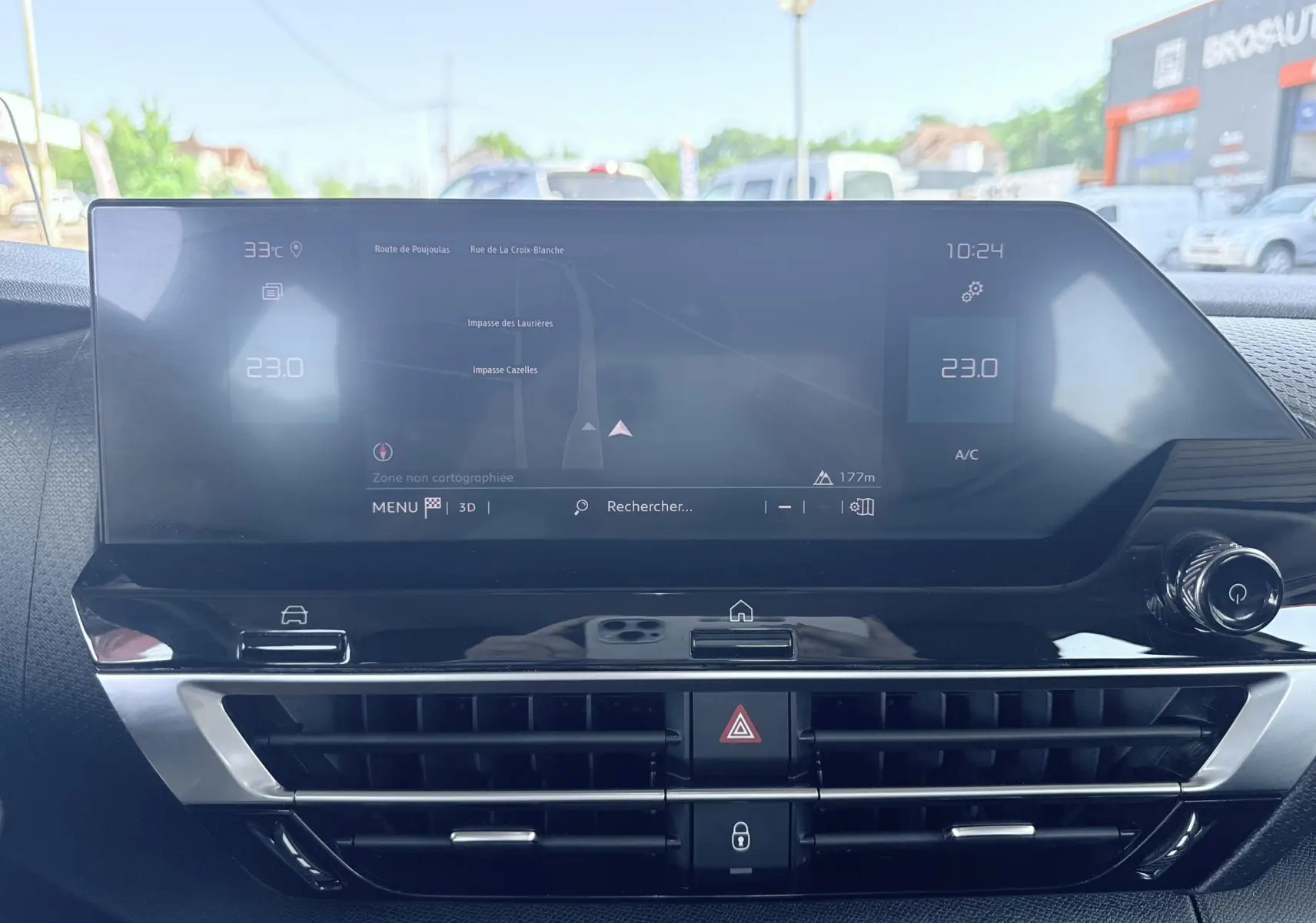 Vue rapprochée de l'écran tactile central et des commandes de climatisation du tableau de bord d'une Citroën C4 blanche.