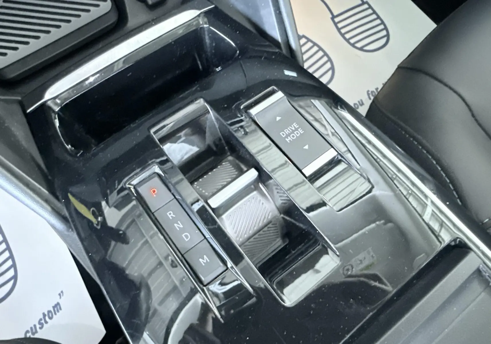 Vue rapprochée de la console centrale noire avec sélecteur de boîte auto et bouton Drive Mode dans une Citroën C4 blanche.