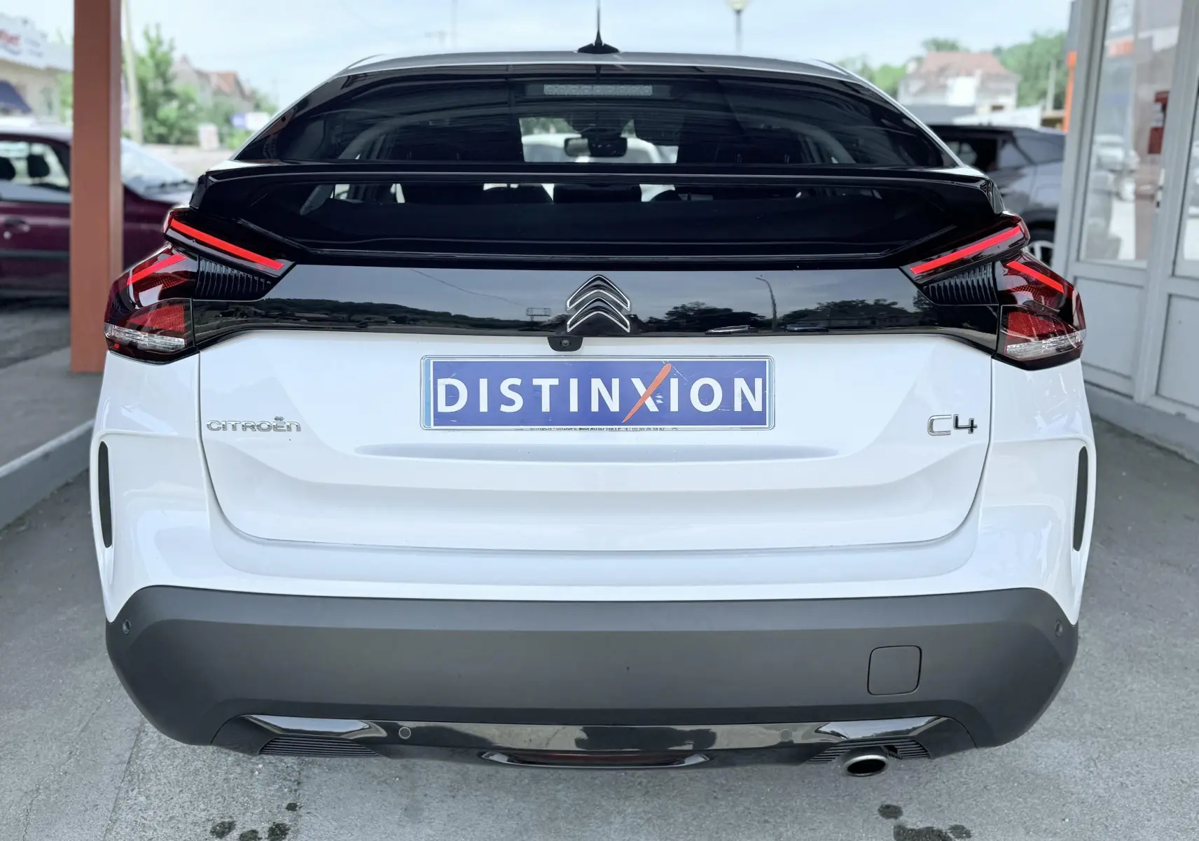 Vue arrière d'une Citroën C4 blanche 2023 avec toit noir et feux arrière LED distinctifs.