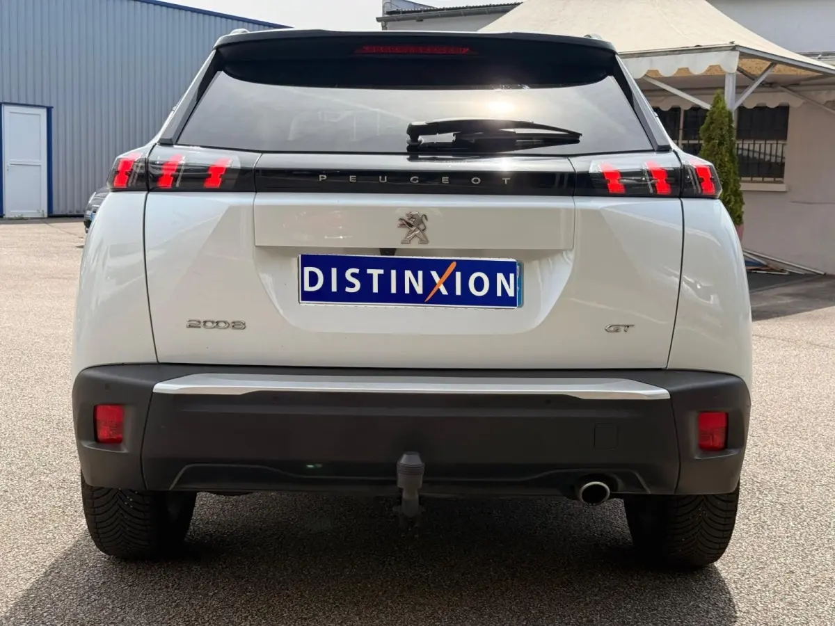 Vue arrière d’un Peugeot 2008 blanc de 2021 avec feux LED caractéristiques et attelage visible.
