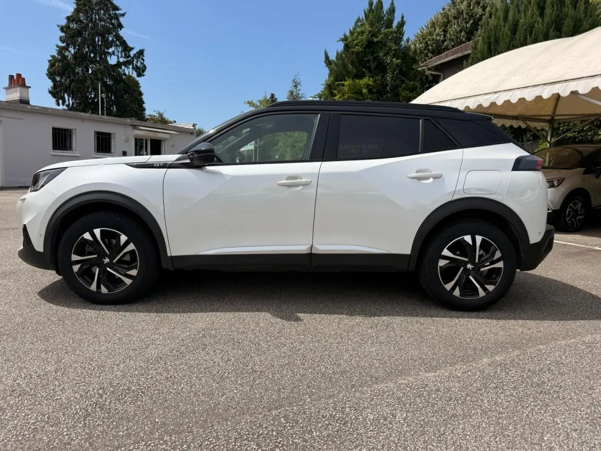 Peugeot 2008 blanc vue de profil côté gauche, toit noir contrastant et jantes alliage bicolores.