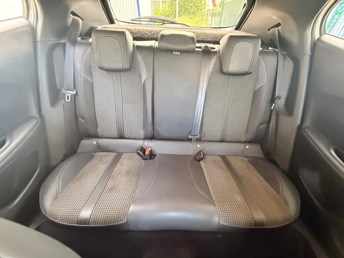 Vue arrière intérieure montrant la banquette arrière en sellerie tri-matière gris foncé du Peugeot 2008 blanc de 2021.