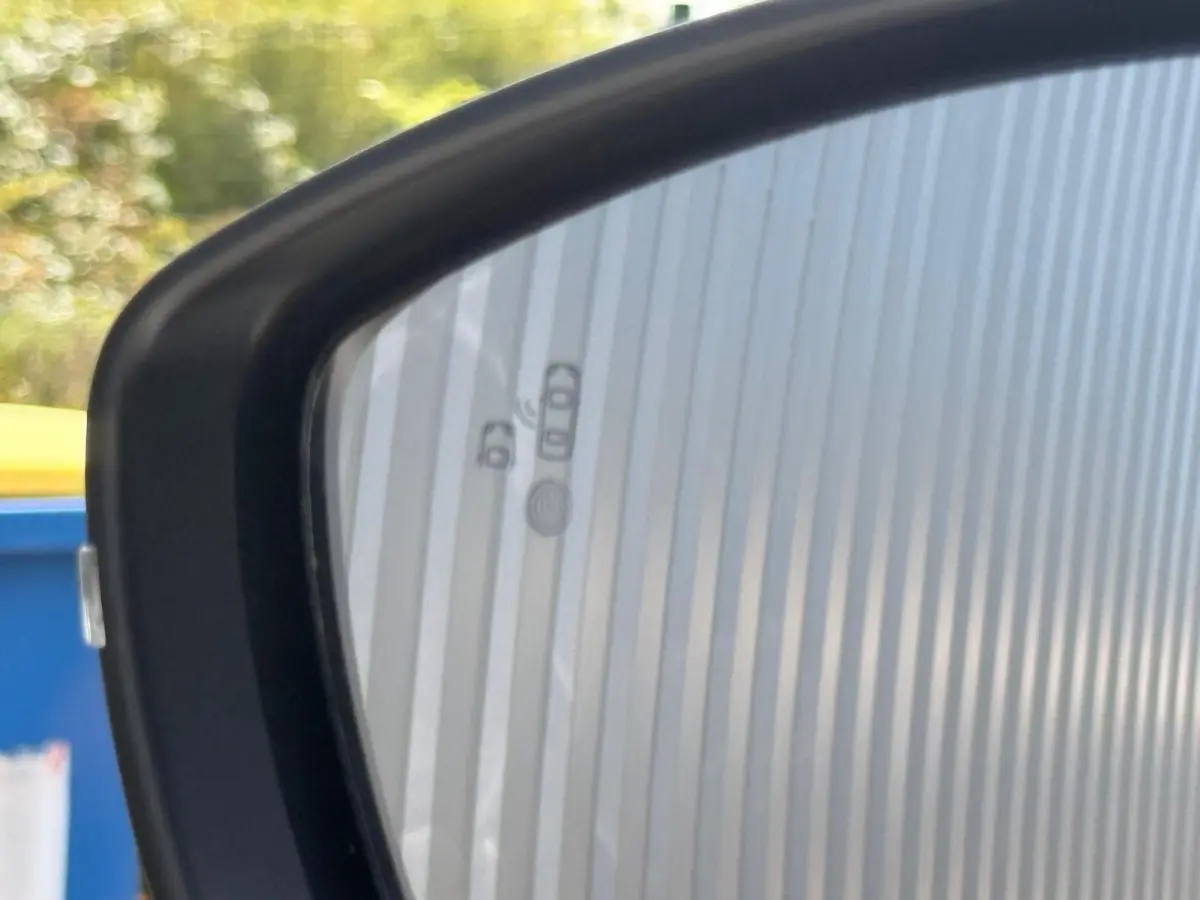 Rétroviseur extérieur gauche du Peugeot 2008 blanc, avec icônes d'alerte d'angle mort visibles sur le miroir.