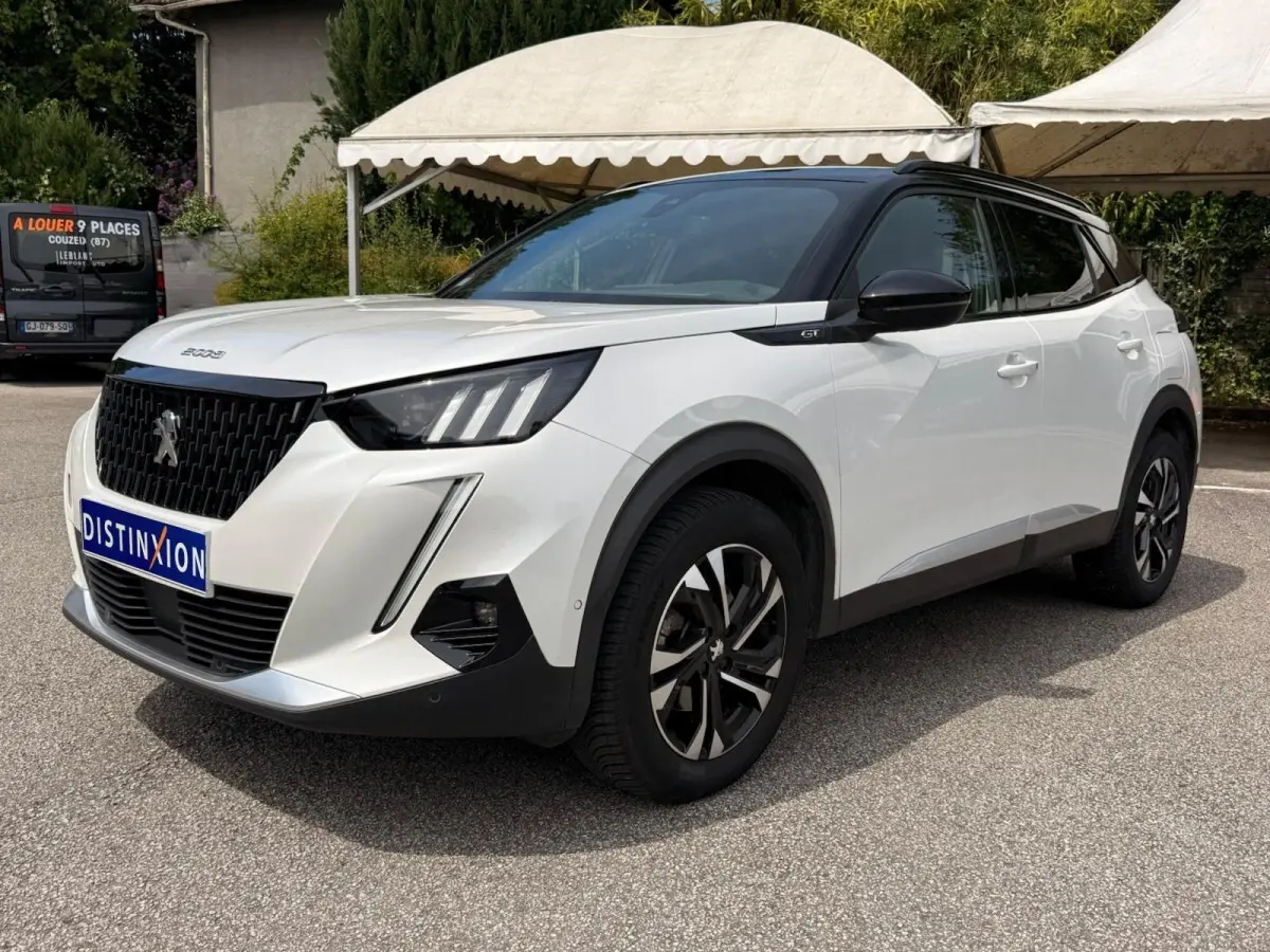 Peugeot 2008 blanc en vue 3/4 avant droit, avec toit noir et jantes alliage bicolores, badge GT visible sur l'aile.